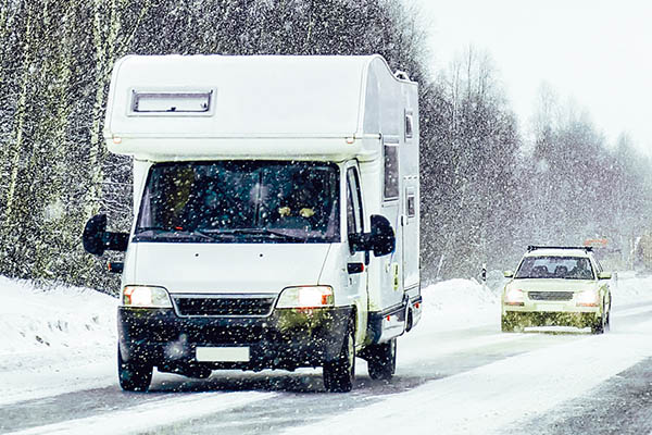 Caravan driving on winter roads after passing winterization rv inspection services 
